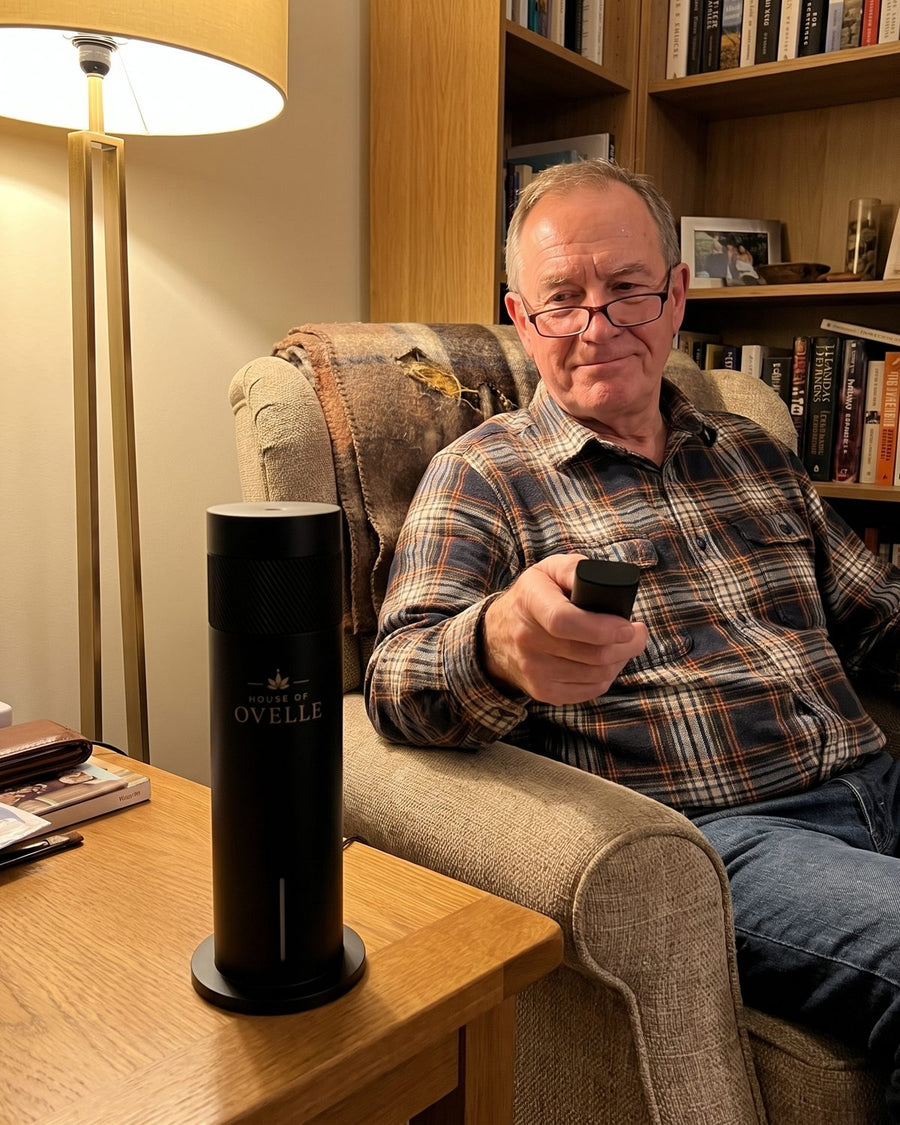 Ovelle Air on a side table next to a reading chair, remote in hand at home